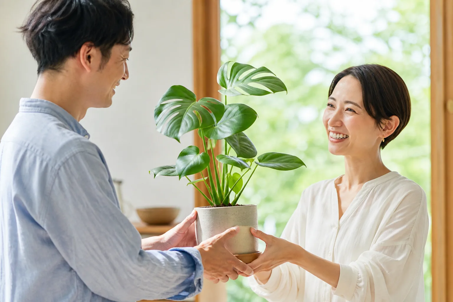 明るい雰囲気のなか、観葉植物を次の方へ引き渡す様子